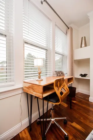 a view of a workspace with furniture and a window