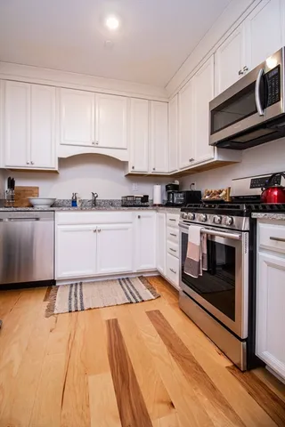 a kitchen with stainless steel appliances granite countertop a stove a sink and a microwave