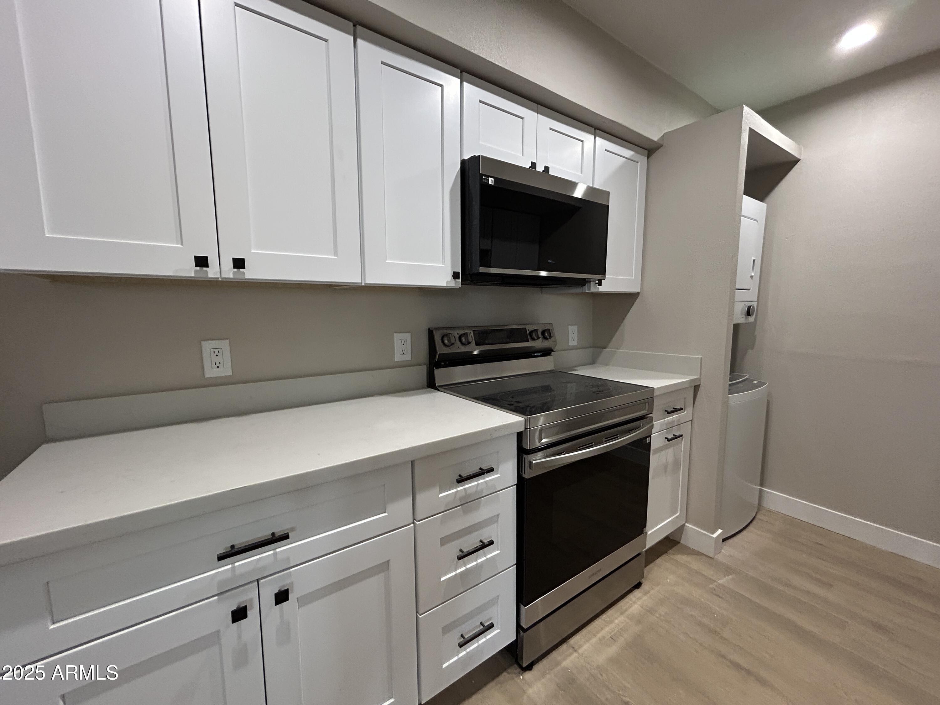 2699 East Silk Oak Drive Tempe, AZ 85288 - Photo 1 of 19 a kitchen with stainless steel appliances a stove a microwave and white cabinets
