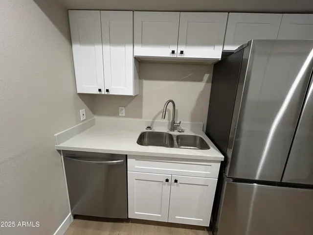 a kitchen with a sink a refrigerator and cabinets