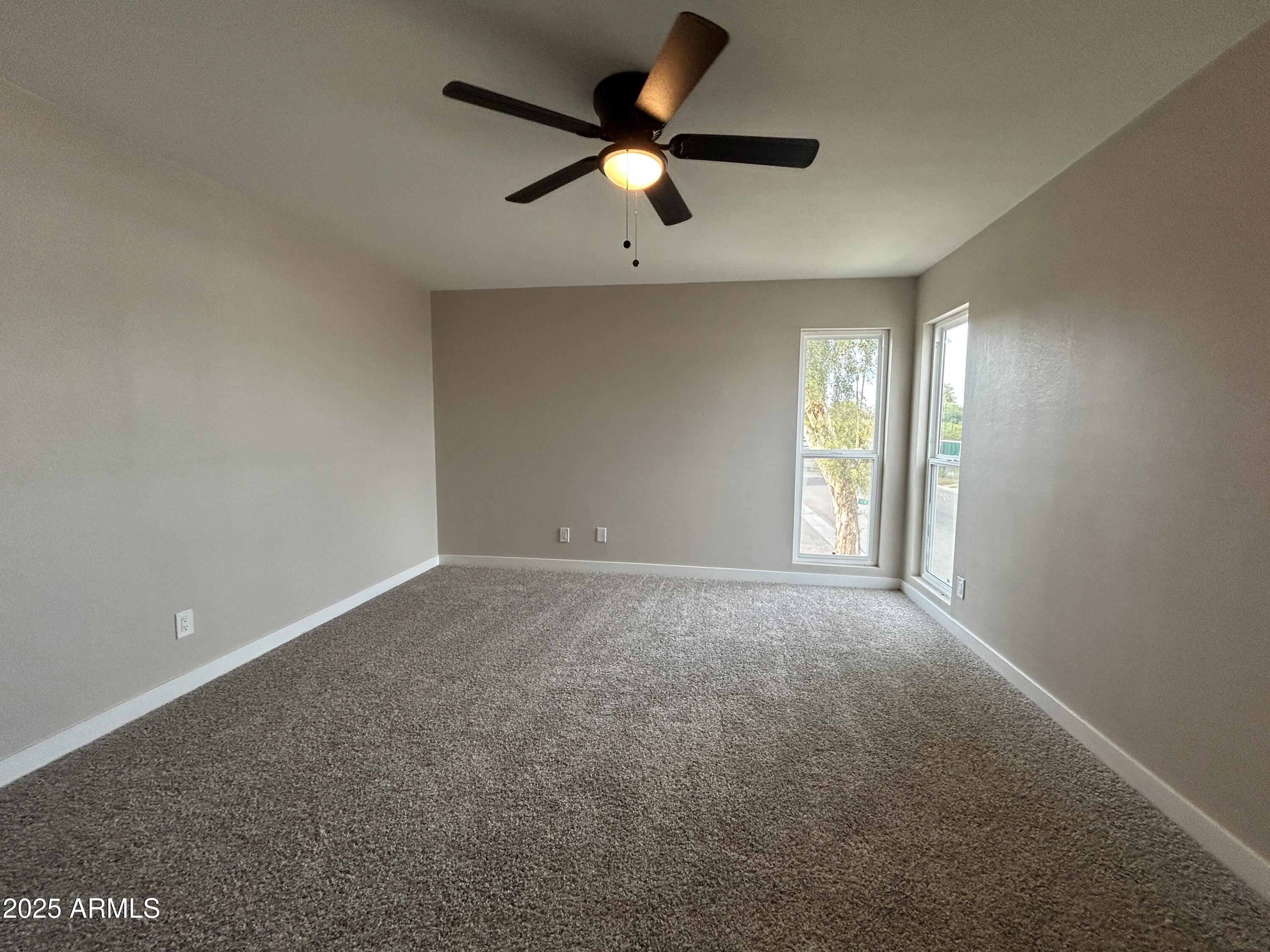 2699 East Silk Oak Drive Tempe, AZ 85288 - Photo 6 of 19 an empty room with ceiling fan and windows