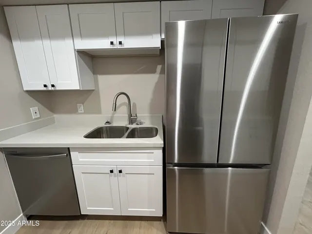a kitchen with a refrigerator sink and cabinets