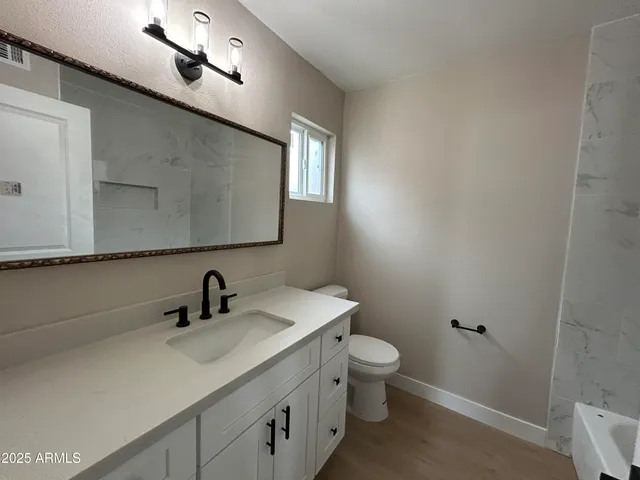 a bathroom with a toilet sink and mirror