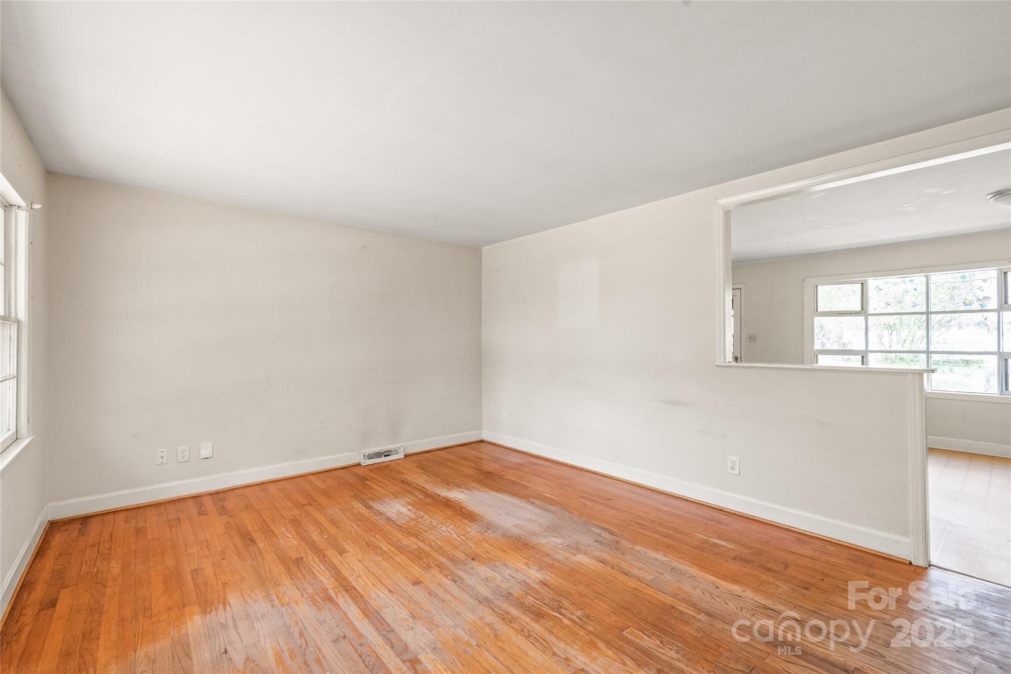 7207 Idlewild Road Charlotte, NC 28212 - Photo 3 of 15 an empty room with wooden floor and windows