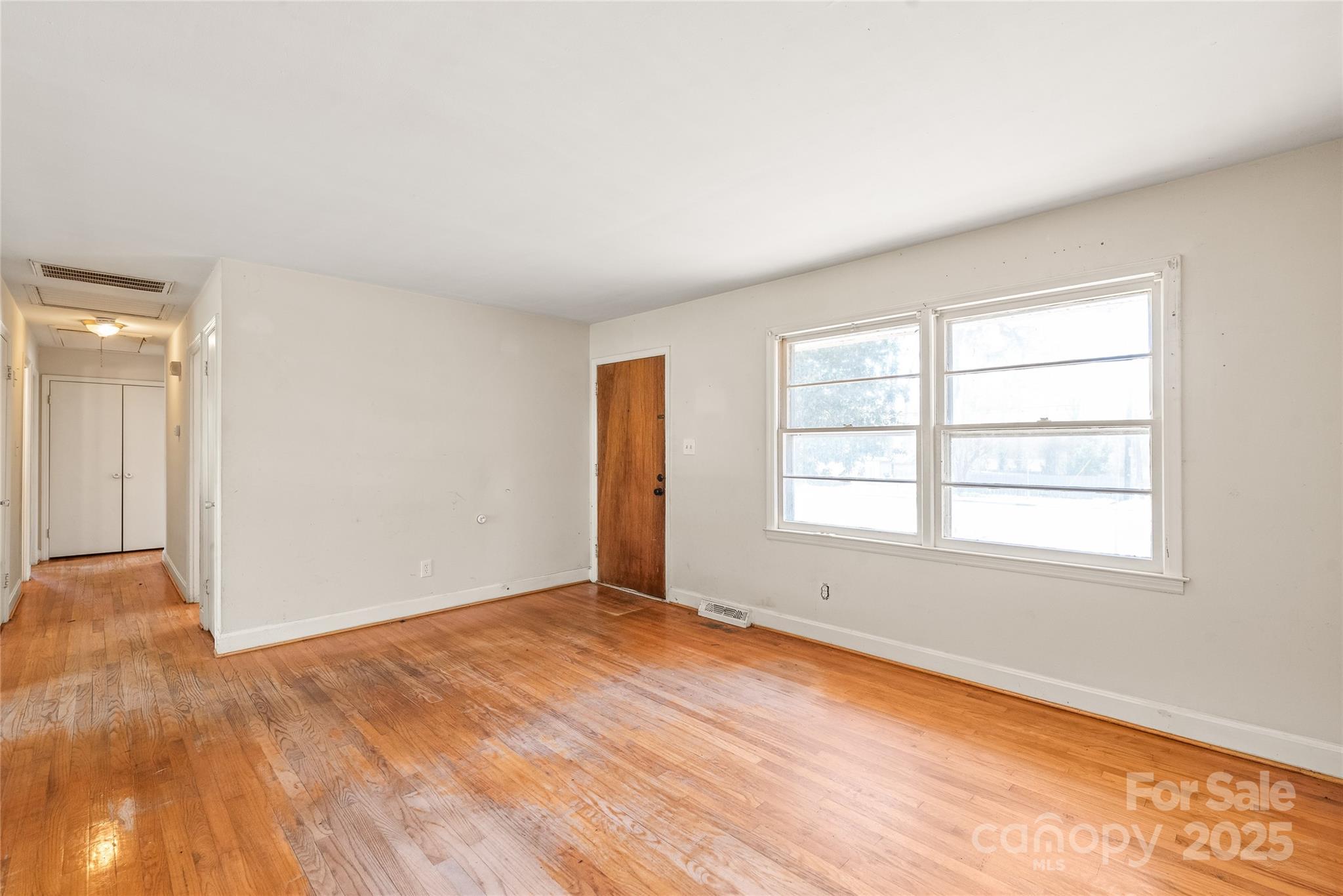 7207 Idlewild Road Charlotte, NC 28212 - Photo 4 of 15 an empty room with wooden floor and windows