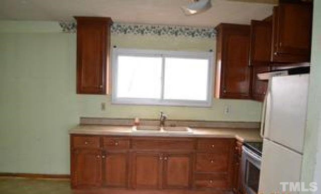 1535 Auctioneer Road Clinton, NC 28328 - Photo 4 of 10 a sink with a cabinet and a refrigerator