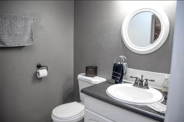 a bathroom with a toilet a sink and a mirror