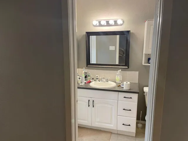 a bathroom with a toilet sink and mirror