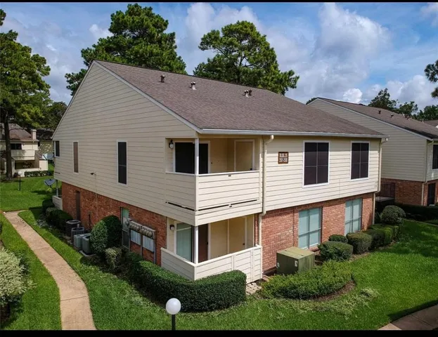 a aerial view of a white house with a yard and potted plants