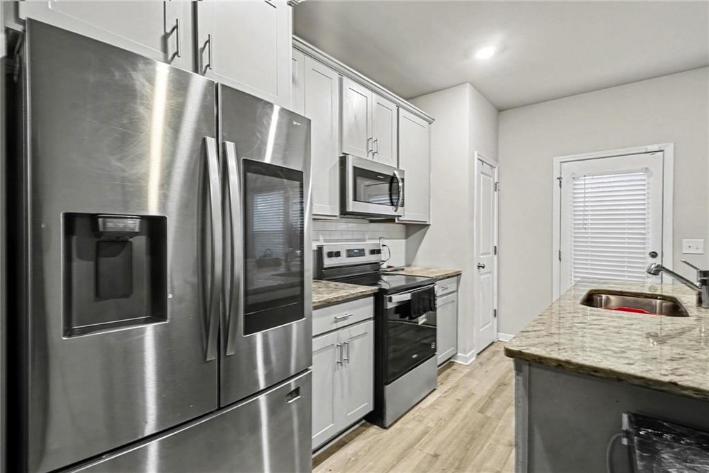 6182 Redan Overlook, Unit 97 Lithonia, GA 30058 - Photo 11 of 23 a kitchen with stainless steel appliances granite countertop a refrigerator and a sink