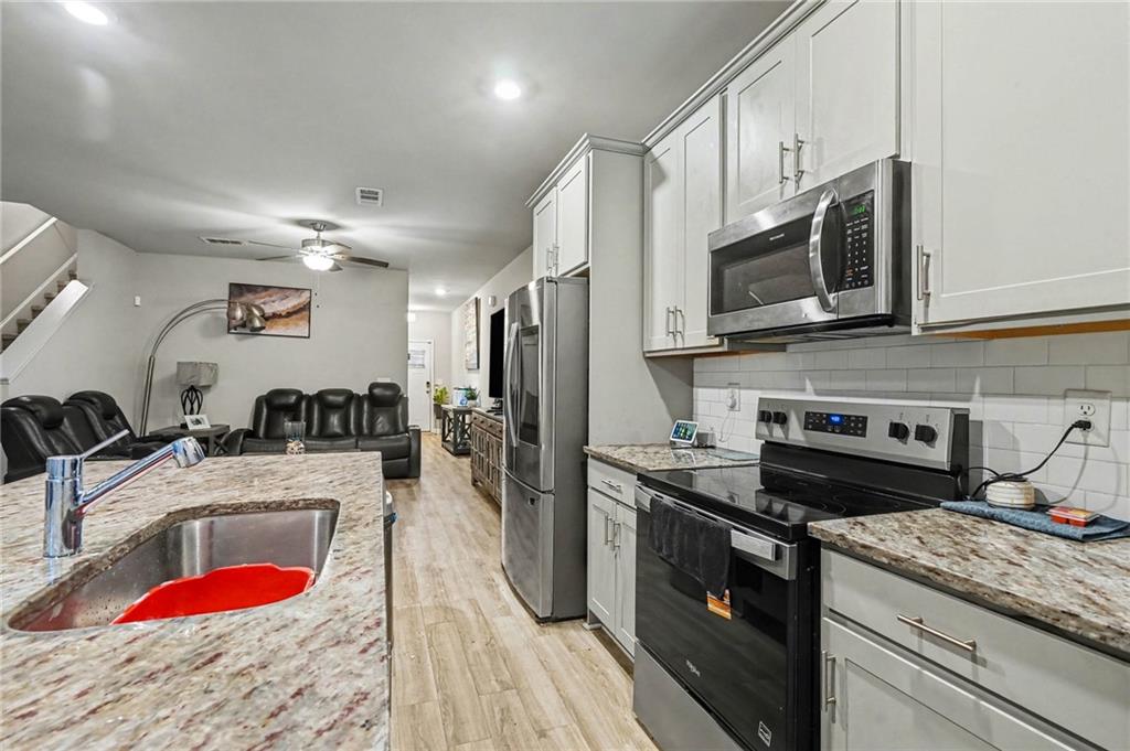 6182 Redan Overlook, Unit 97 Lithonia, GA 30058 - Photo 12 of 23 a kitchen with stainless steel appliances granite countertop a sink stove and refrigerator