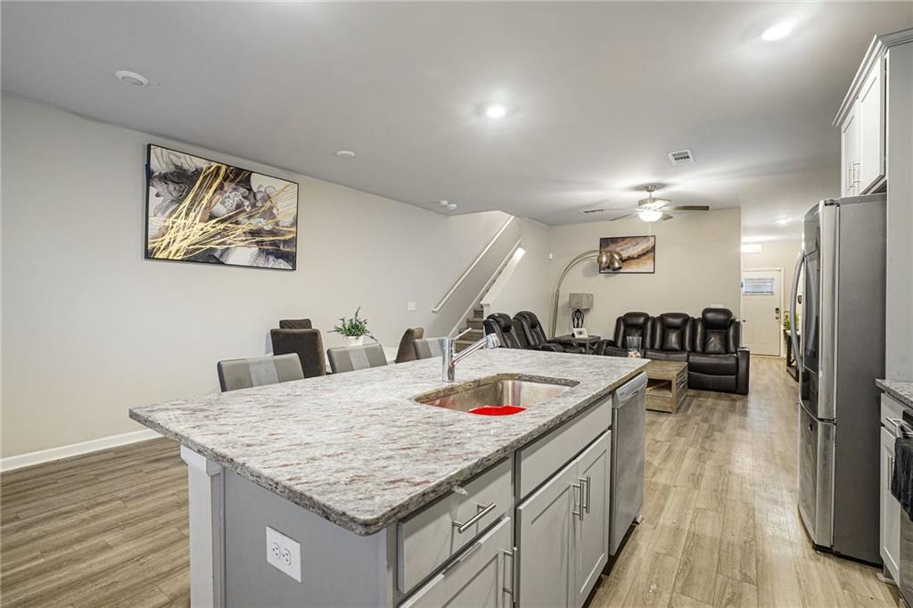 6182 Redan Overlook, Unit 97 Lithonia, GA 30058 - Photo 9 of 23 a kitchen with stainless steel appliances granite countertop a sink dishwasher and a refrigerator with wooden floor
