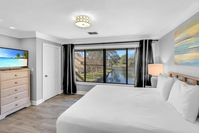 a view of a room that has a large window and wooden floor