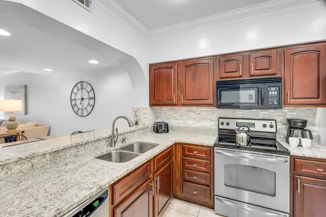 a kitchen with stainless steel appliances granite countertop a sink a stove and cabinets