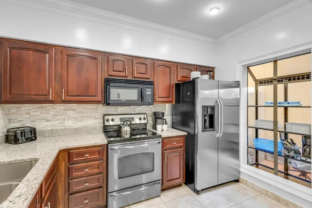 a kitchen with stainless steel appliances granite countertop a refrigerator and a stove top oven