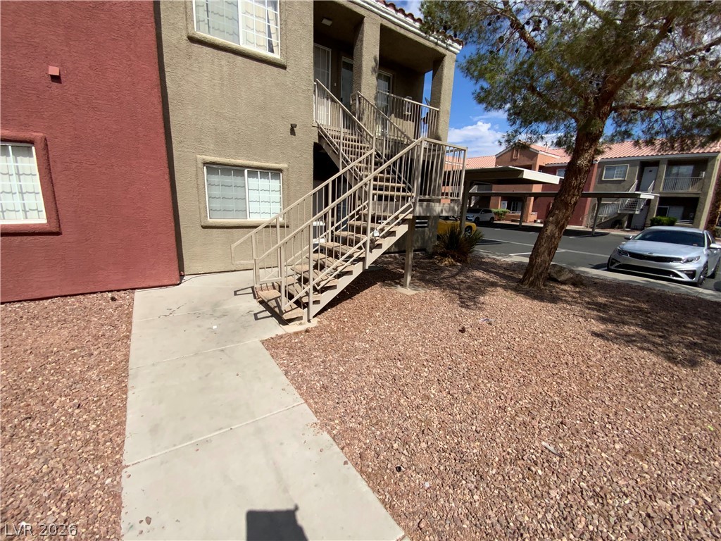 Concrete pathways lead to apartment access, surrounded by low-maintenance xeriscape landscaping.