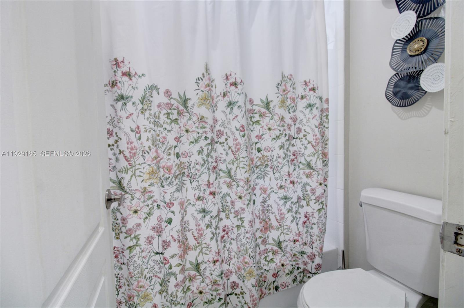 1156 Northeast 37th Place Homestead, FL 33033 - Photo 22 of 35 a bathroom with a toilet and a shower curtain