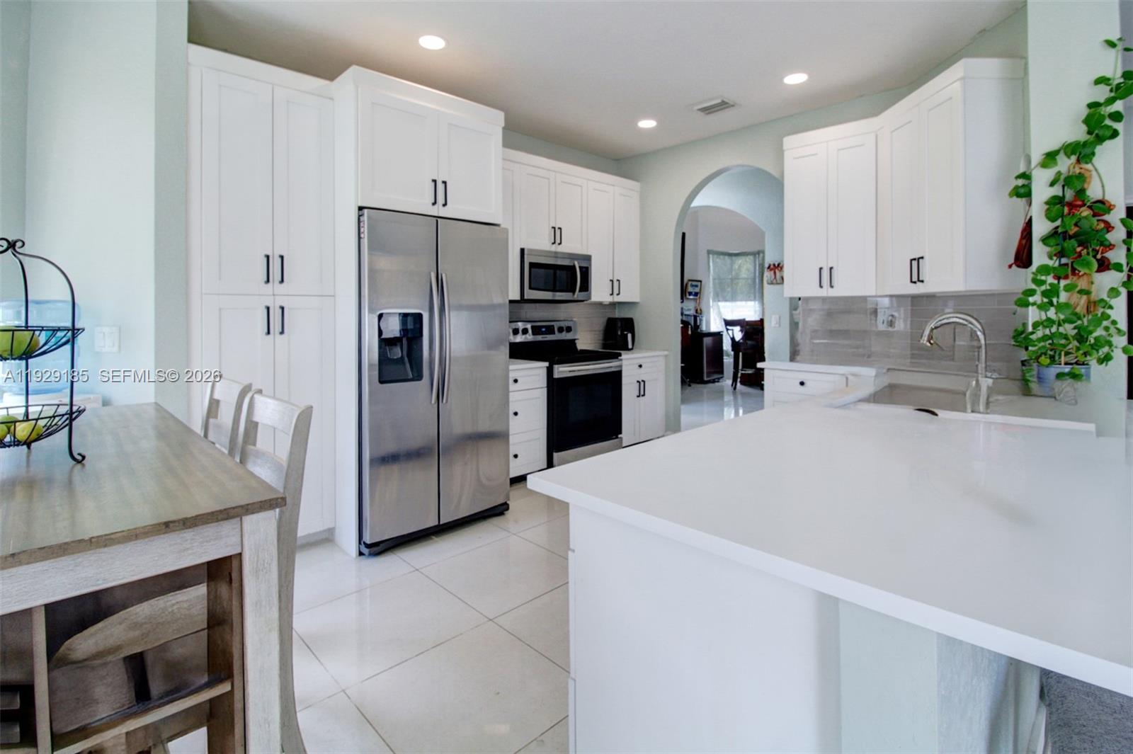 1156 Northeast 37th Place Homestead, FL 33033 - Photo 5 of 35 a kitchen with refrigerator and cabinets