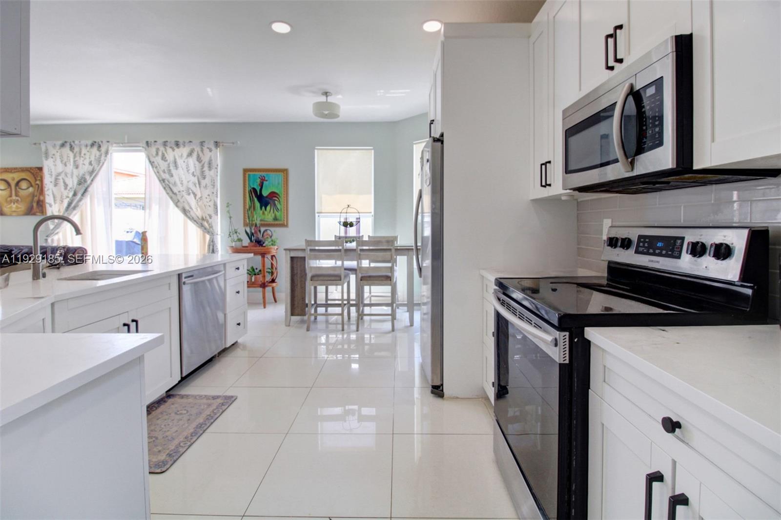 1156 Northeast 37th Place Homestead, FL 33033 - Photo 6 of 35 a kitchen with stainless steel appliances a stove a sink a cabinets and a refrigerator