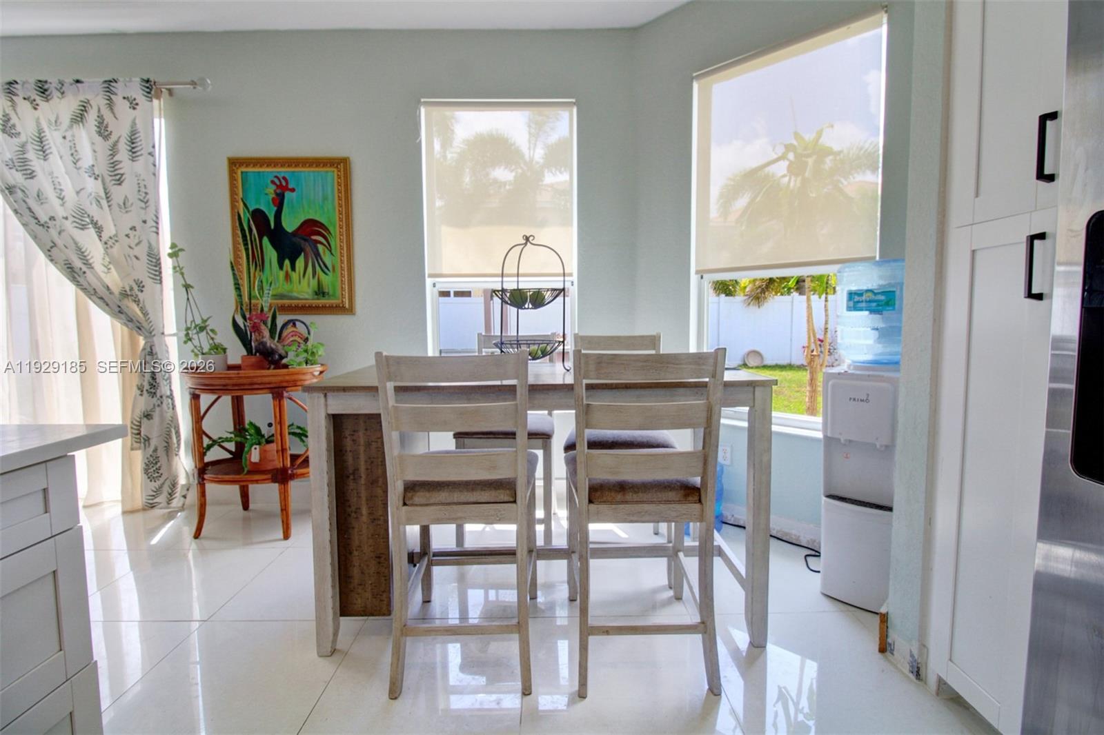 1156 Northeast 37th Place Homestead, FL 33033 - Photo 7 of 35 a dining room with furniture a kitchen view and a painting on the wall