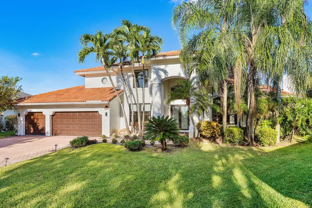 a front view of a house with a yard and potted plants