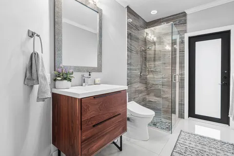a bedroom with a large bed and a chandelier next to a window