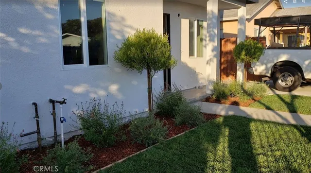 a view of a house with a yard and potted plants