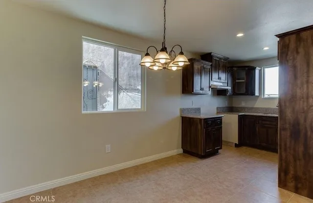 a kitchen with granite countertop a stove a sink a refrigerator and a microwave