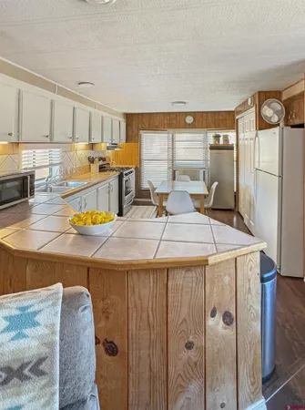 a kitchen with a refrigerator a stove and a sink with wooden floor