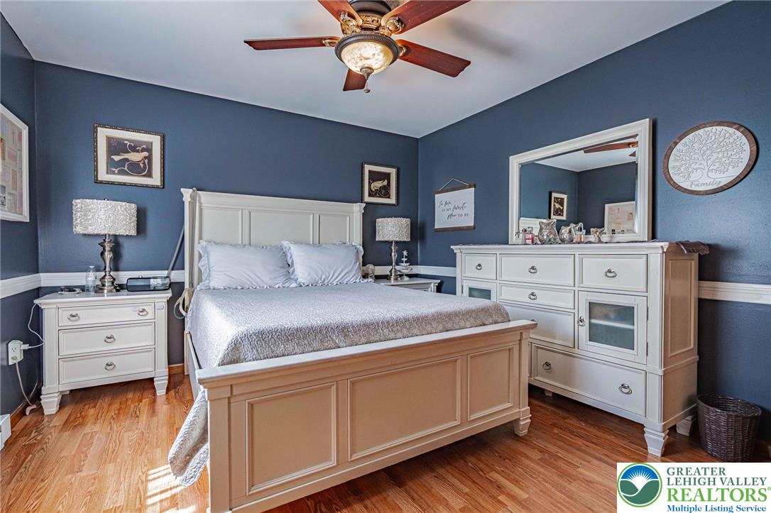 341 Lower Greenhill Road Kunkletown, PA 18058 - Photo 20 of 69 Wood flooring grounds this comfortable bedroom, featuring a classic ceiling fan for optimal air circulation.