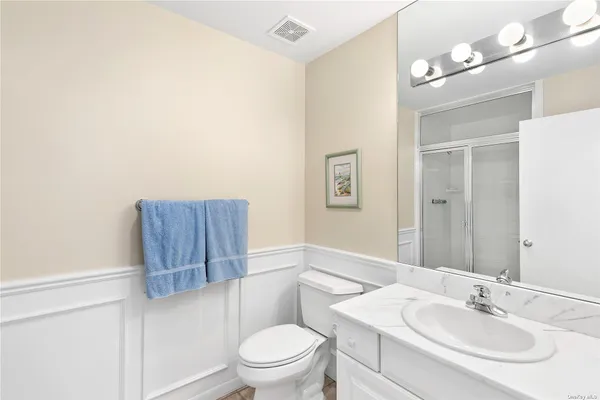 a bathroom with a toilet a sink a mirror and vanity