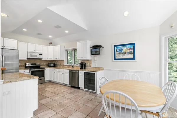 a kitchen with a stove a sink a dining table and chairs
