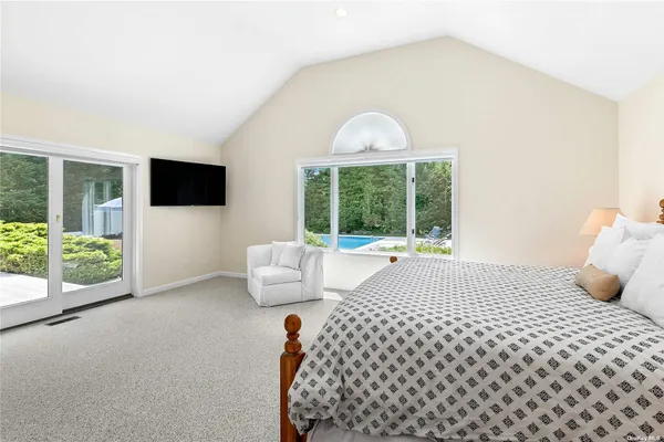 a bedroom with a bed and a large window