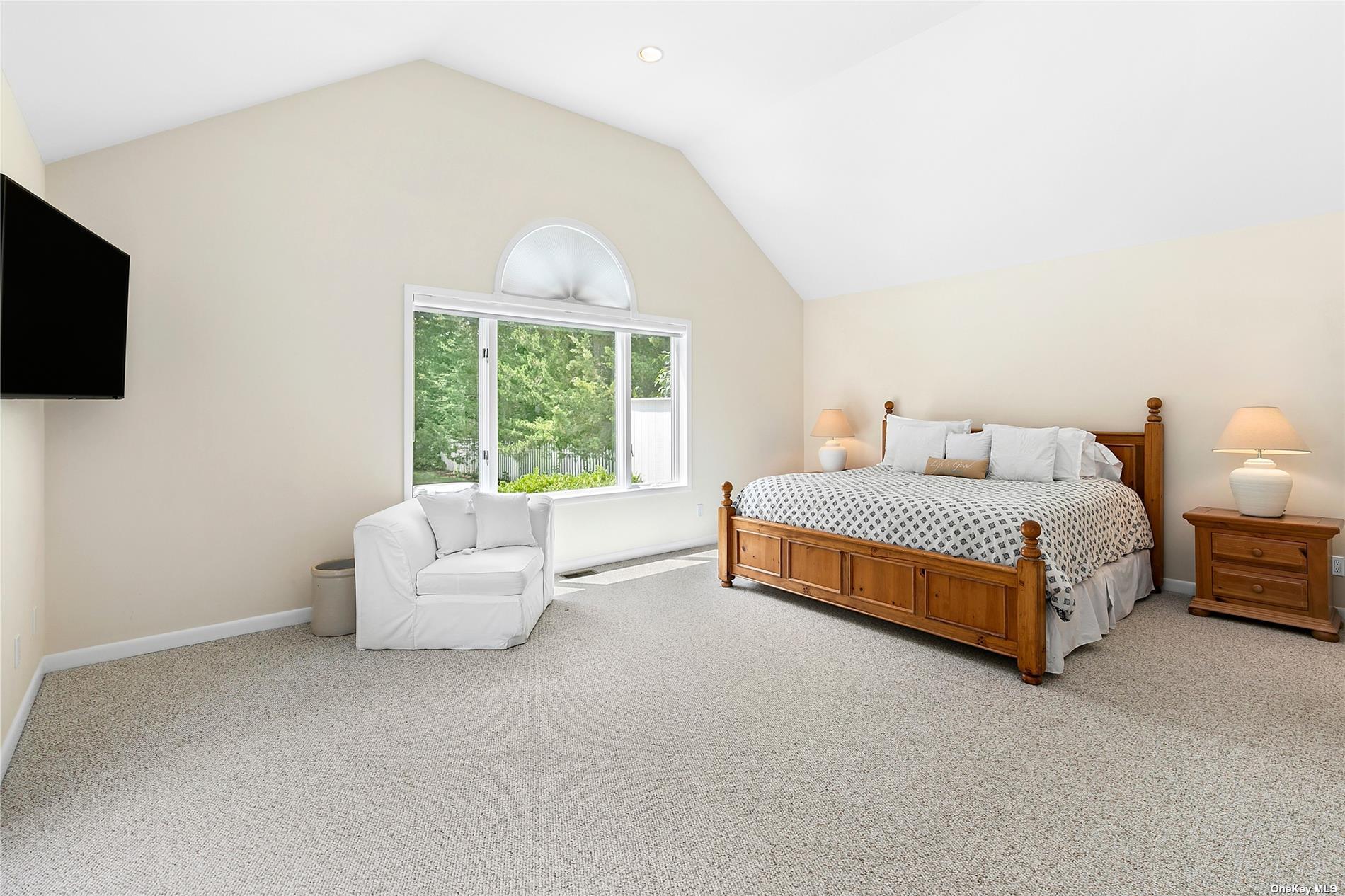 43 Bridle Path Westhampton Beach, NY 11978 - Photo 8 of 15 a spacious bedroom with a bed and a flat screen tv