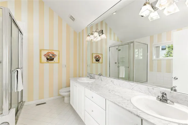 a spacious bathroom with a double vanity sink mirror and a shower