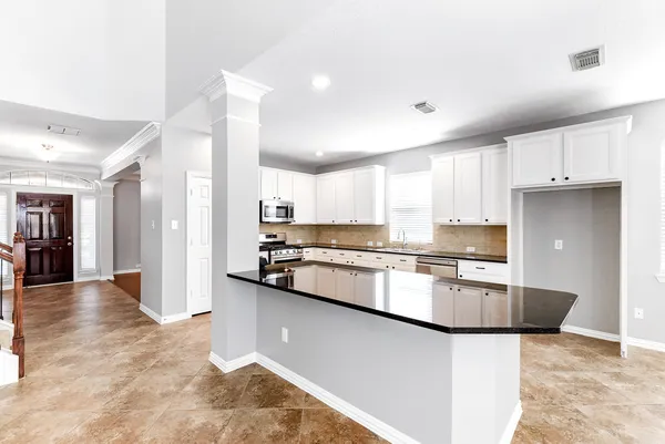 a kitchen with stainless steel appliances granite countertop a sink refrigerator and cabinets