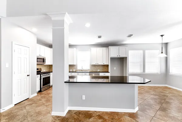 a kitchen with stainless steel appliances granite countertop a refrigerator a stove and a sink