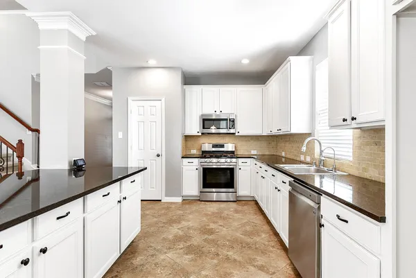 a large kitchen with stainless steel appliances granite countertop a stove sink and cabinets