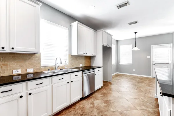 a kitchen with granite countertop white cabinets and white appliances