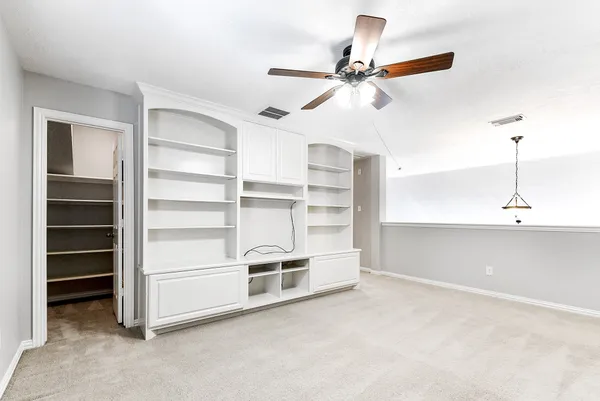 a view of an empty room with a ceiling fan