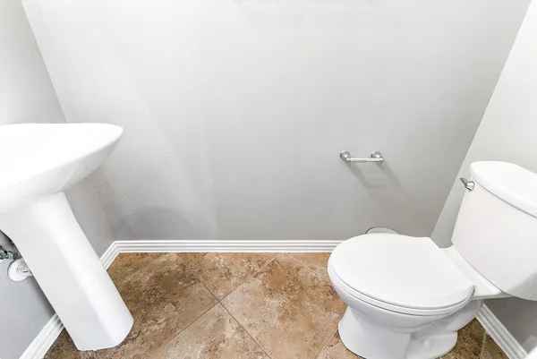 a white toilet sitting next to a white sink