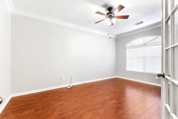 an empty room with a window and a fan