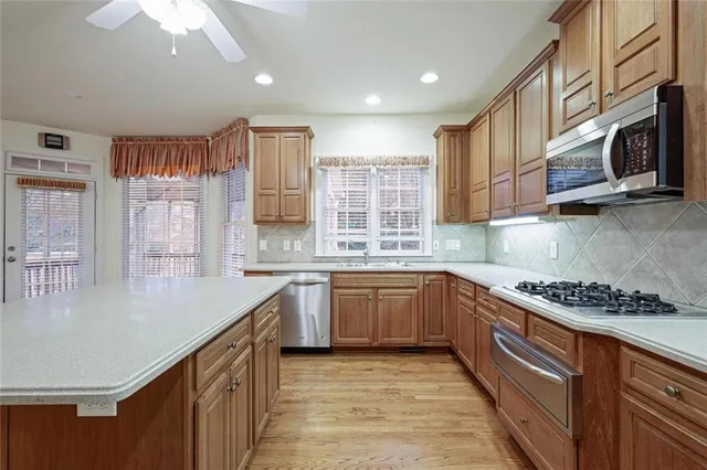 a kitchen with stainless steel appliances granite countertop a stove a sink and a microwave