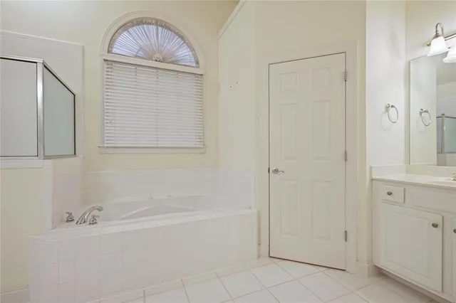 a bathroom with a tub shower and vanity