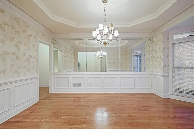 a view of a livingroom with a chandelier wooden floor and a chandelier