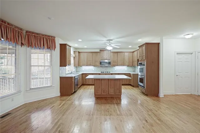 a large kitchen with a large counter top space and stainless steel appliances