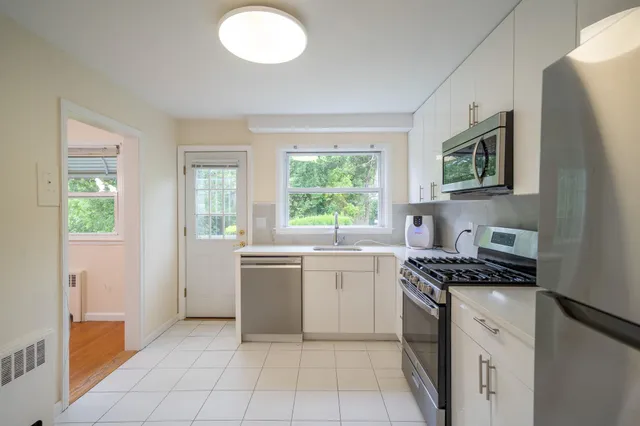 a kitchen with stainless steel appliances granite countertop a stove a sink and a microwave