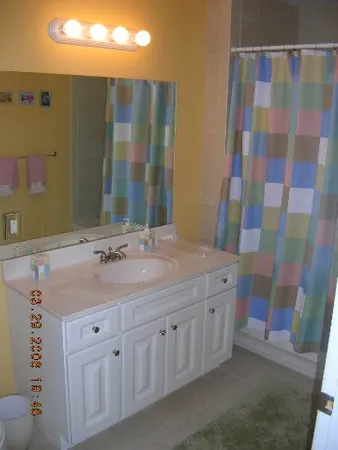 a bathroom with a sink a toilet a mirror a shower and vanity