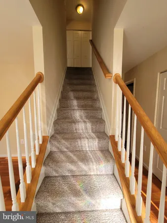a view of staircase with wooden floor and white walls