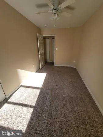 an empty room with a ceiling fan and window